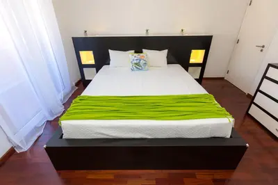 a bedroom with a large bed with a green blanket at Casa dos Avós by Rent2U, Lda in Funchal