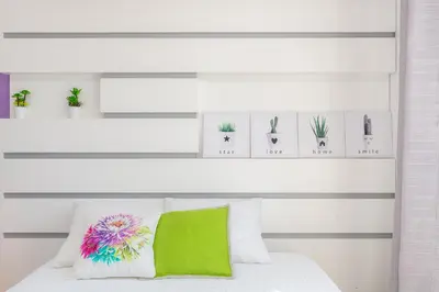 a bedroom with a white bed with a green pillow at Casa dos Avós by Rent2U, Lda in Funchal