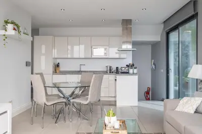 a kitchen and living room with a glass table and chairs at Hillside Villa in Arco da Calheta