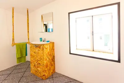 a bathroom with a sink and a window at The Pallet - Guest House in Santa Cruz
