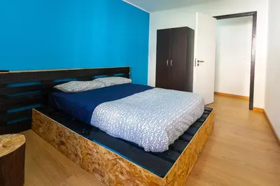 a bed in a room with a blue wall at The Pallet - Guest House in Santa Cruz