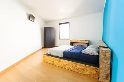 a bedroom with a bed with a wooden frame at The Pallet - Guest House in Santa Cruz