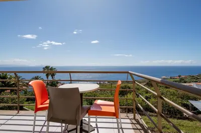 a balcony with a table and chairs and the ocean at Caniço I By Trip2Portugal in Caniço