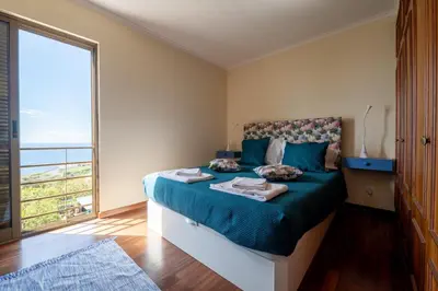 a bedroom with a bed and a large window at Caniço I By Trip2Portugal in Caniço