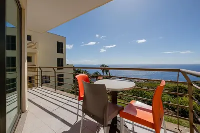 a balcony with a table and chairs and the ocean at Caniço I By Trip2Portugal in Caniço