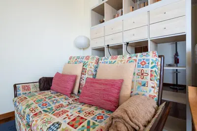 a couch with colorful pillows sitting in a living room at Caniço I By Trip2Portugal in Caniço
