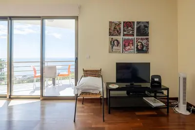 a living room with a television and a table with a desk at Caniço I By Trip2Portugal in Caniço