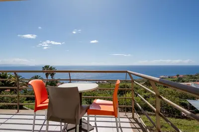 a balcony with a table and chairs and the ocean at Caniço I By Trip2Portugal in Caniço