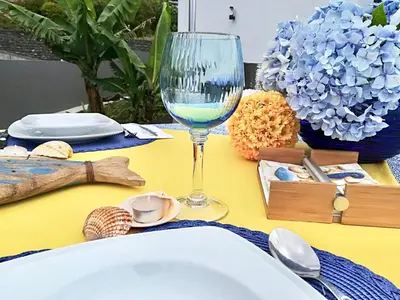 a table with a wine glass on a yellow table at Moradia Syso in Arco da Calheta