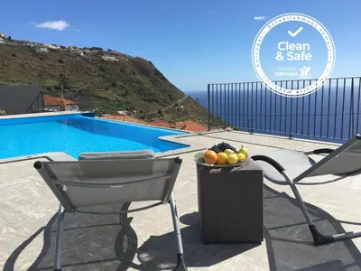 a chair and a bowl of fruit next to a pool at Moradia Syso in Arco da Calheta