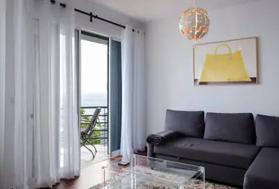 a living room with a couch and a glass table at Lobos Bay-Apartment With Unique Sea Views in Câmara de Lobos