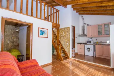 a kitchen and a living room with a staircase in a house at Akivillas Lagos Quiet in Barão de São Miguel