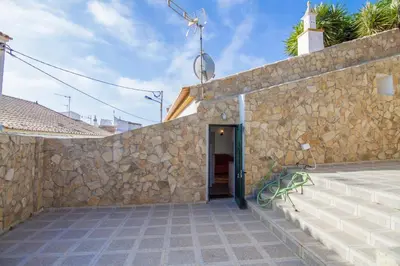 a building with a stone wall and a door at Akivillas Lagos Quiet in Barão de São Miguel