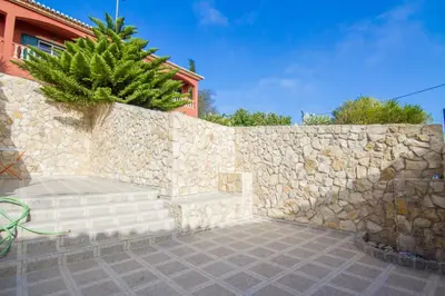 a stone retaining wall with a bench against a stone wall at Akivillas Lagos Quiet in Barão de São Miguel