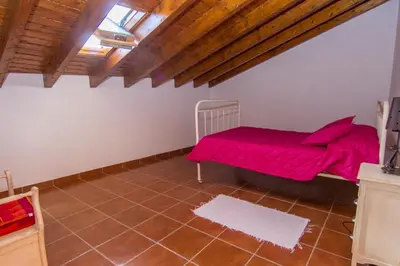 a bedroom with a red bed and a wooden ceiling at Akivillas Lagos Quiet in Barão de São Miguel