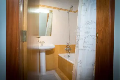 a bathroom with a sink and a shower curtain at Helen´s House Apartment in Câmara de Lobos
