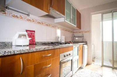 a kitchen with wooden cabinets and a stove top oven at Helen´s House Apartment in Câmara de Lobos