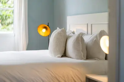 a bedroom with a bed with white pillows and a window at Barreirinha II Near Old Town With Nice Ocean Views in Funchal