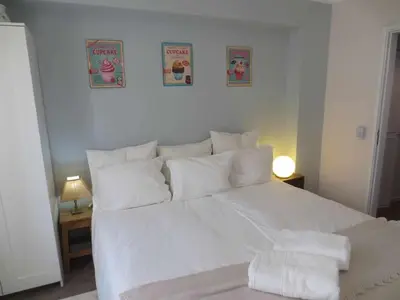 a white bed in a bedroom with two pictures on the wall at Barreirinha II Near Old Town With Nice Ocean Views in Funchal