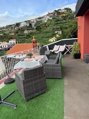 a patio with a table and chairs on the grass at Ponta do Sol Villa in Ponta do Sol
