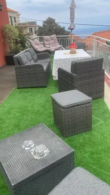 a patio with couches and tables on the grass at Ponta do Sol Villa in Ponta do Sol