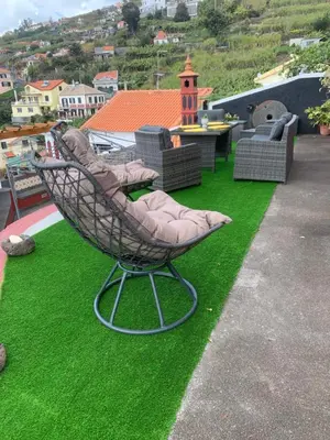 a chair sitting on the grass on a roof at Ponta do Sol Villa in Ponta do Sol