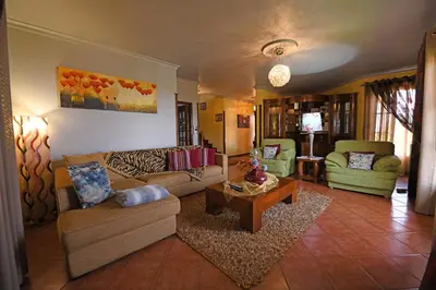 a living room with two couches and a table at Ponta do Sol Villa in Ponta do Sol