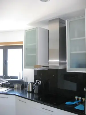 a kitchen with white cabinets and black counter tops at Casa dos Filhos by Rent2U, Lda in Funchal