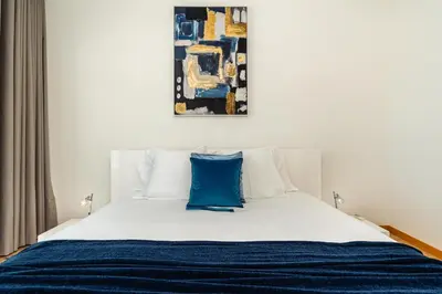 a bedroom with a white bed with a blue pillow at Casa dos Filhos by Rent2U, Lda in Funchal