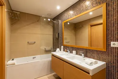 a bathroom with a sink and a tub and a mirror at Casa dos Filhos by Rent2U, Lda in Funchal