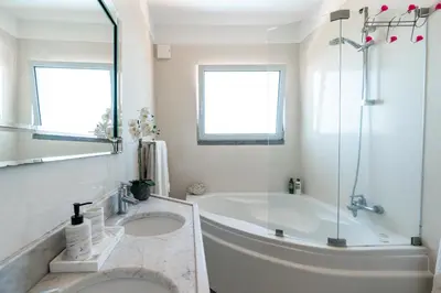 a white bathroom with a tub and a shower at Villa Abreu - A Wonderful Ocean View in Calheta