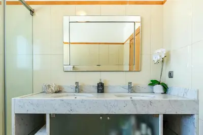 a bathroom with two sinks and a large mirror at Villa Abreu - A Wonderful Ocean View in Calheta