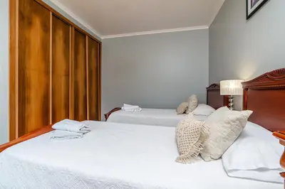two beds in a hotel room with white sheets at Villa Abreu - A Wonderful Ocean View in Calheta