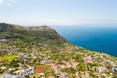 an aerial view of a village on a hill next to the ocean at Villa Abreu - A Wonderful Ocean View in Calheta