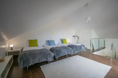 a room with three beds with pillows and a rug at Casa da Graça by AnaLodges in Machico