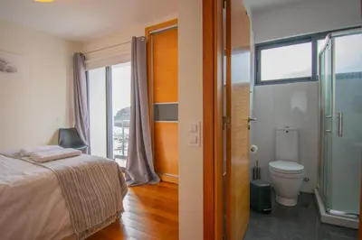 a bedroom with a bed and a toilet and a window at Casa da Graça by AnaLodges in Machico