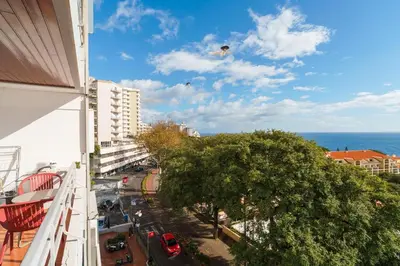 two kites are flying in the sky over a street at Lido Mar - Hotels area in Funchal