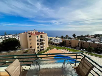 a balcony with a view of the ocean and buildings at Garajau Terrace - Amazing Views of Garajau Town in Garajau