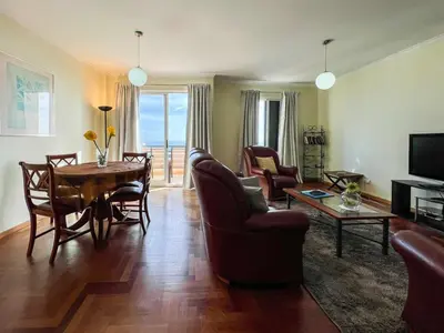 a living room with a table and chairs and a dining room at Garajau Terrace - Amazing Views of Garajau Town in Garajau