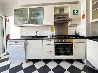 a kitchen with white appliances and a checkered floor at Garajau Terrace - Amazing Views of Garajau Town in Garajau