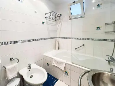 a bathroom with a sink and a tub and a toilet at Garajau Terrace - Amazing Views of Garajau Town in Garajau