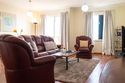 a living room with a leather couch and two chairs at Garajau Terrace - Amazing Views of Garajau Town in Garajau