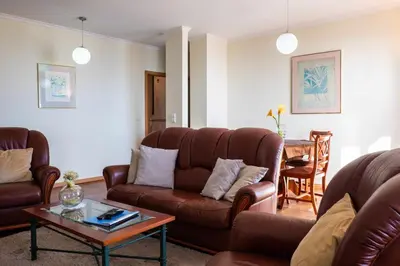 a living room with leather couches and a table at Garajau Terrace - Amazing Views of Garajau Town in Garajau