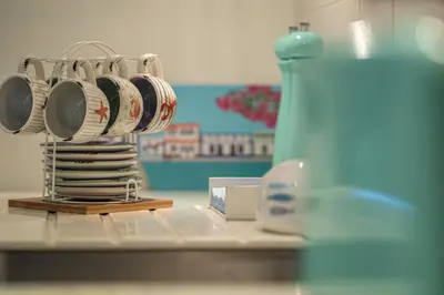 a group of coffee cups on a rack next to a sink at Atlantic Ocean View Apartment in Funchal