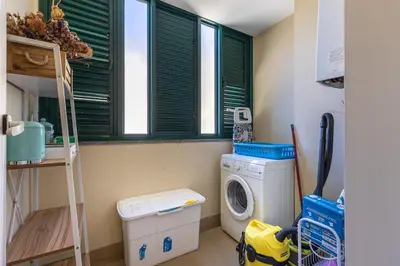 a laundry room with a washing machine and a window at Atlantic Ocean View Apartment in Funchal
