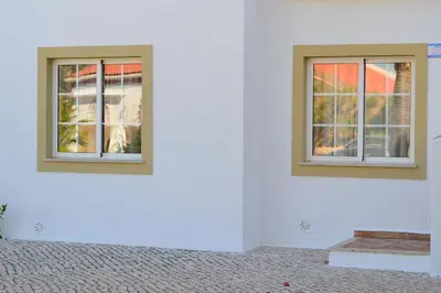 two windows on the side of a white wall at Palm Bay Apartment in Luz