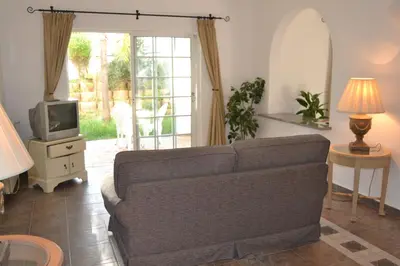 a living room with a couch and a tv at Palm Bay Apartment in Luz