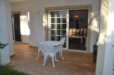 a white table and chairs on a patio at Palm Bay Apartment in Luz