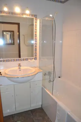 a bathroom with a sink and a shower and a tub at Palm Bay Apartment in Luz
