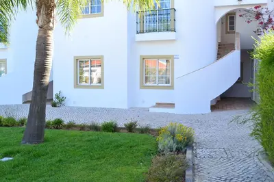 a white house with a palm tree in the yard at Palm Bay Apartment in Luz